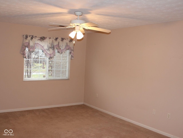 carpeted spare room featuring a textured ceiling and ceiling fan