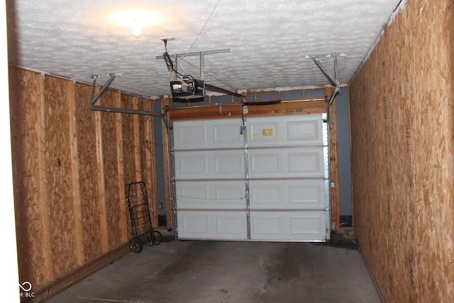 garage with a garage door opener and wooden walls