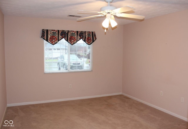 carpeted empty room featuring ceiling fan and a textured ceiling