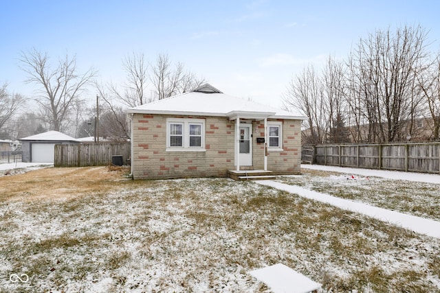 bungalow-style house with central AC unit, an outdoor structure, and a garage