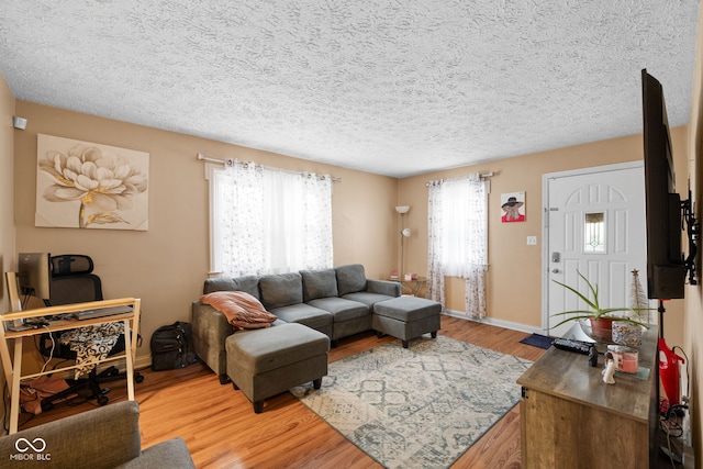 living room with plenty of natural light, wood-type flooring, and a textured ceiling