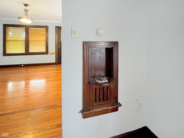 hall featuring crown molding and light hardwood / wood-style floors