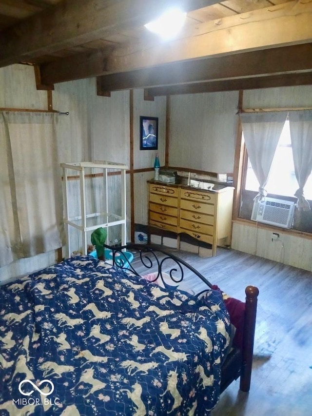 bedroom with hardwood / wood-style floors, cooling unit, and beamed ceiling