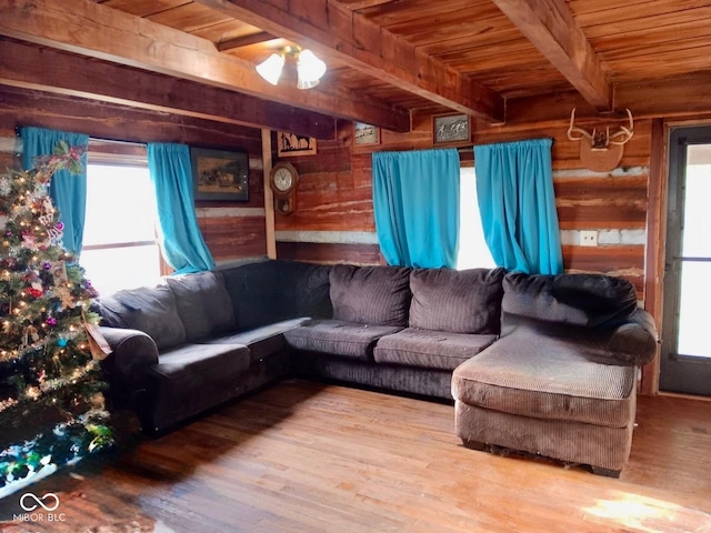 living room featuring beam ceiling, hardwood / wood-style flooring, rustic walls, and wooden ceiling