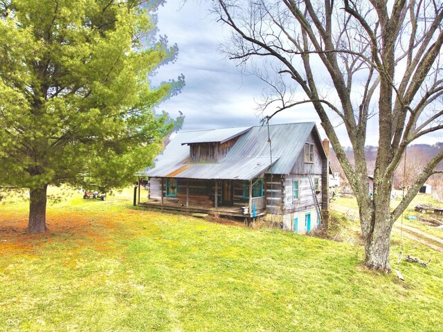 back of house with a lawn and covered porch