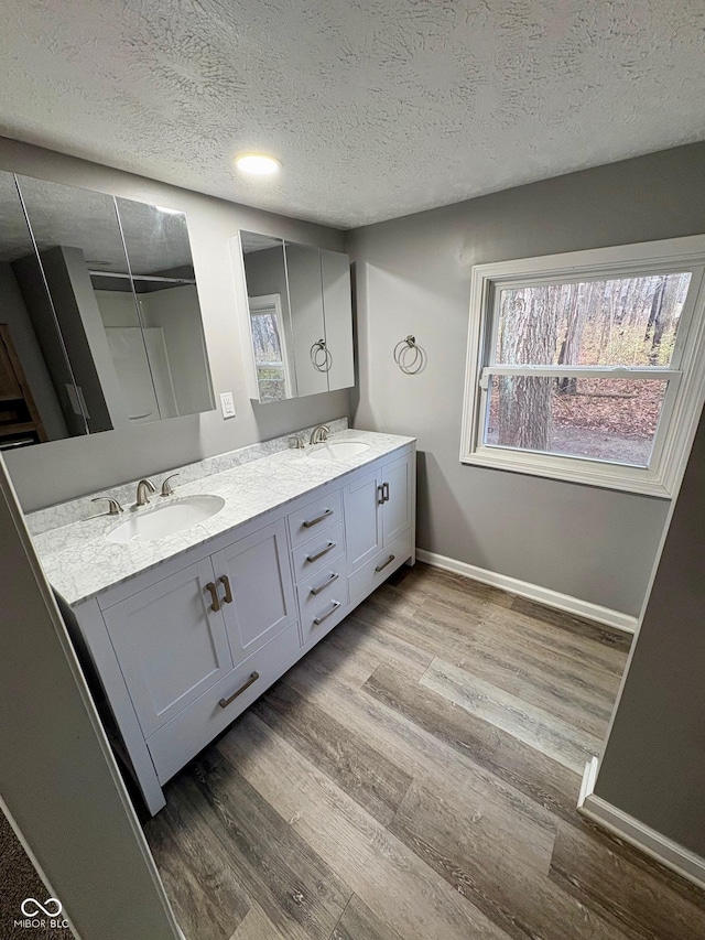 bathroom with hardwood / wood-style floors, vanity, and a textured ceiling