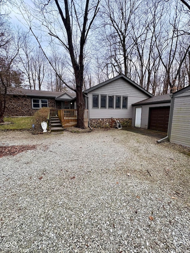 rear view of house featuring a wooden deck and a garage