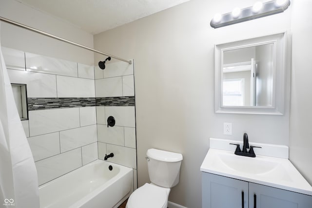 full bathroom with vanity, a textured ceiling, toilet, and tiled shower / bath