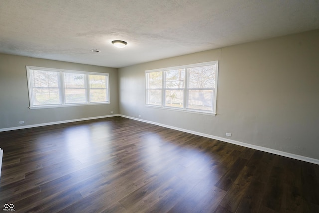 spare room with a textured ceiling and dark wood-type flooring