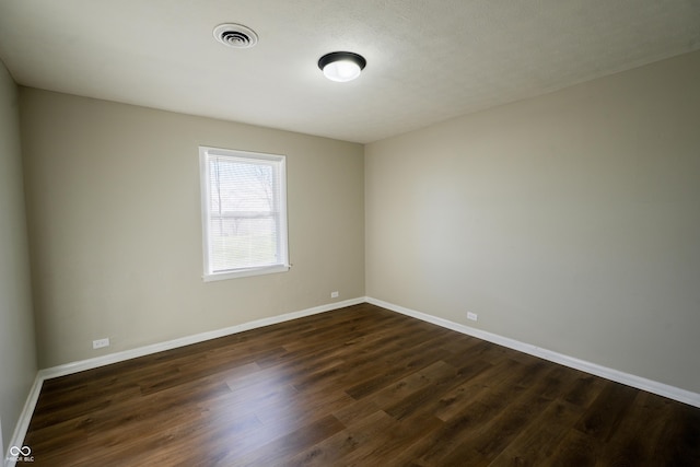 unfurnished room featuring a textured ceiling and dark hardwood / wood-style floors