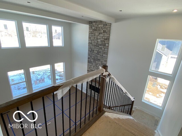 stairway with a healthy amount of sunlight and beamed ceiling