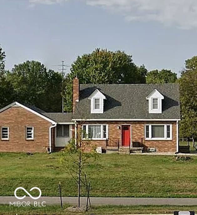 cape cod home with a front lawn