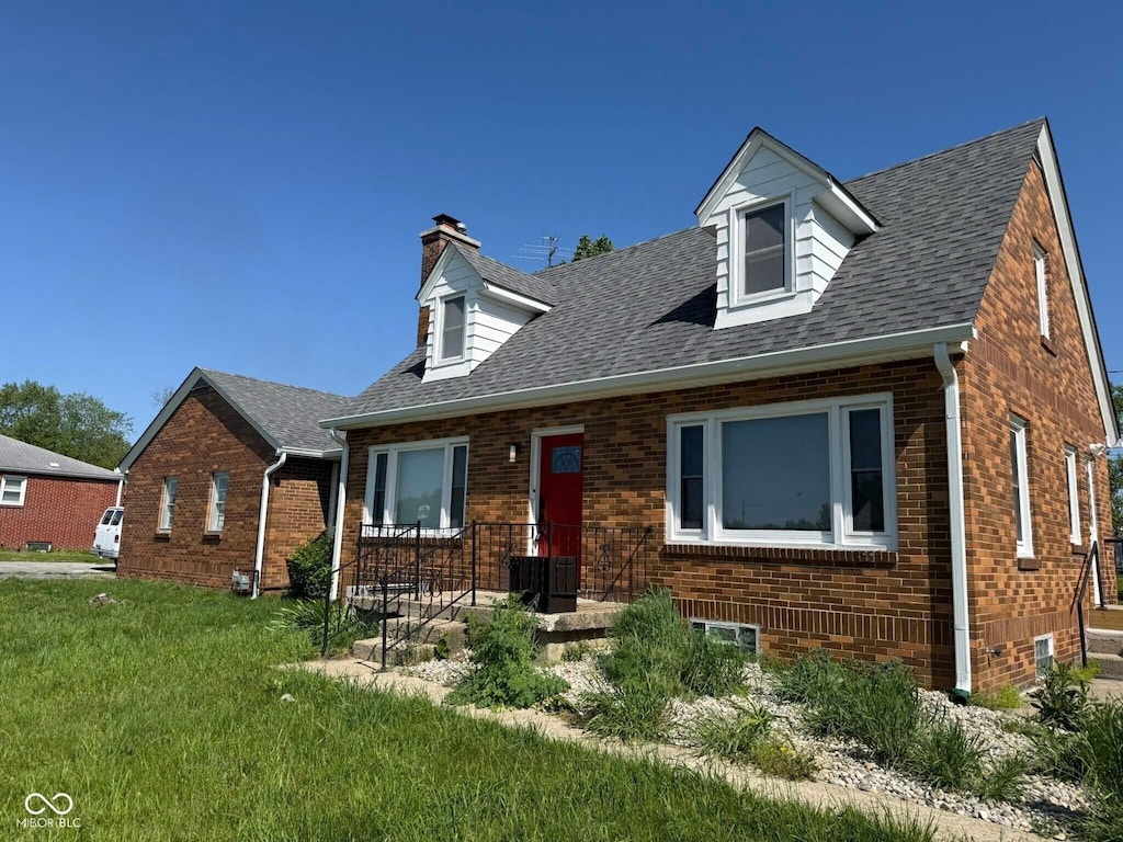 3192 E Main St, Plainfield, IN 46168 - cape cod house featuring brick siding, a chimney, a front lawn, and roof with shingles