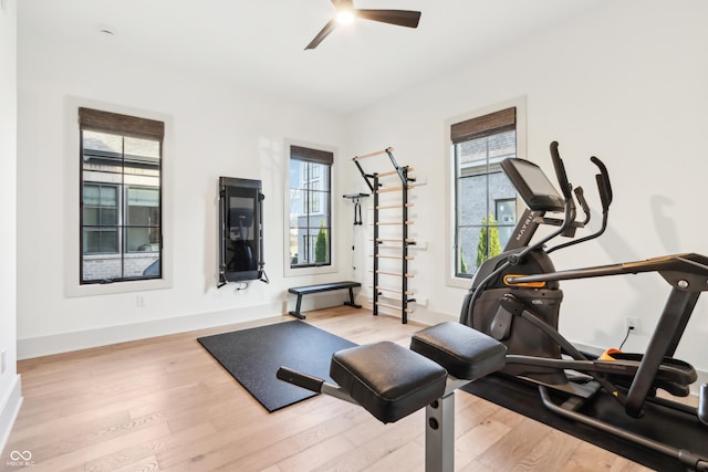 exercise room with ceiling fan, a healthy amount of sunlight, and light hardwood / wood-style floors