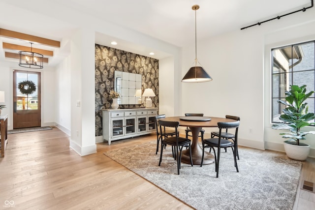 dining space featuring plenty of natural light, an inviting chandelier, and light wood-type flooring