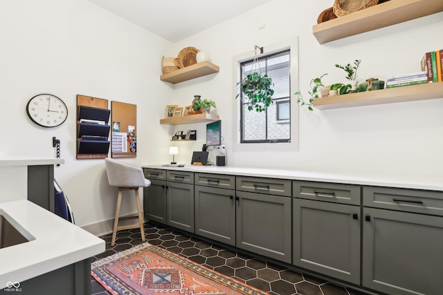 kitchen featuring gray cabinets and dark tile patterned floors