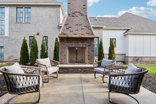 view of patio featuring an outdoor brick fireplace