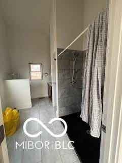 bathroom featuring tile patterned floors and tiled shower