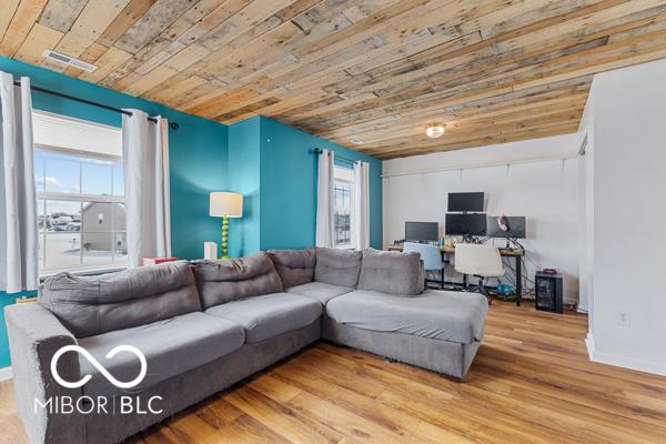 living room with a wealth of natural light, wooden ceiling, and light hardwood / wood-style floors