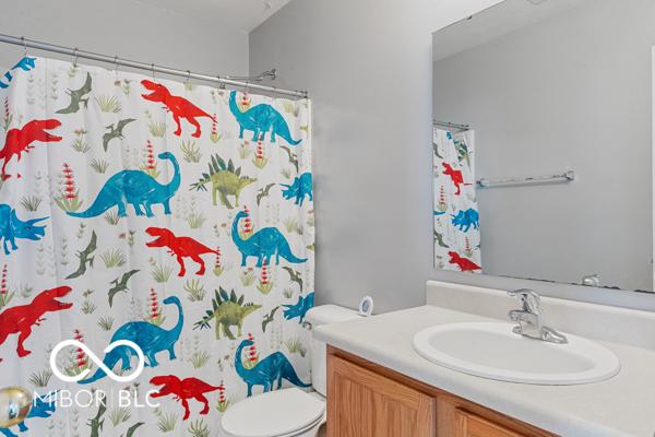 bathroom featuring vanity, toilet, and curtained shower