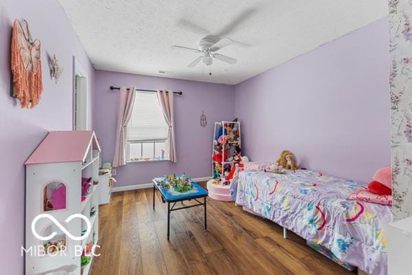 bedroom featuring a textured ceiling, ceiling fan, and dark wood-type flooring