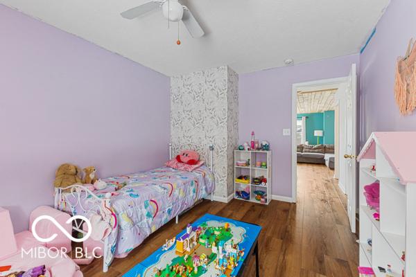 bedroom with dark hardwood / wood-style flooring and ceiling fan