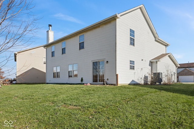 rear view of house with a lawn and central AC unit