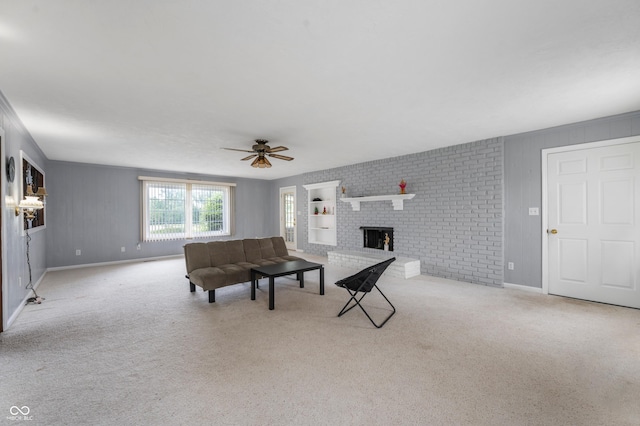 carpeted living room featuring ceiling fan, brick wall, and a brick fireplace