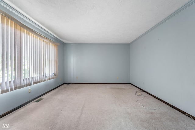 unfurnished room featuring a textured ceiling, crown molding, and light carpet