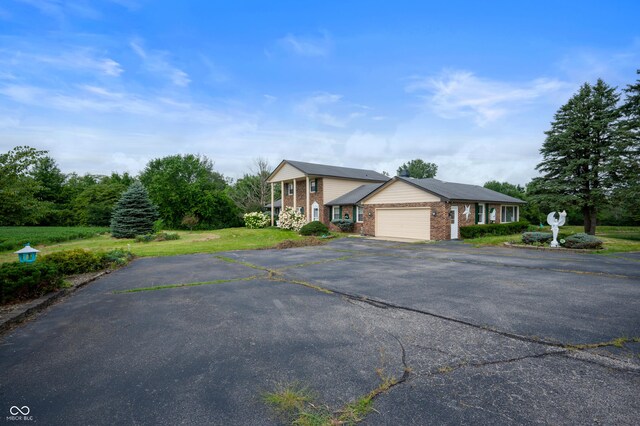4832 E 200 N, Anderson, IN 46012 - view of front facade with brick siding, driveway, an attached garage, and a front lawn