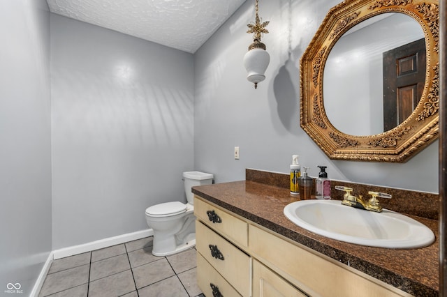 bathroom with tile patterned flooring, vanity, toilet, and a textured ceiling