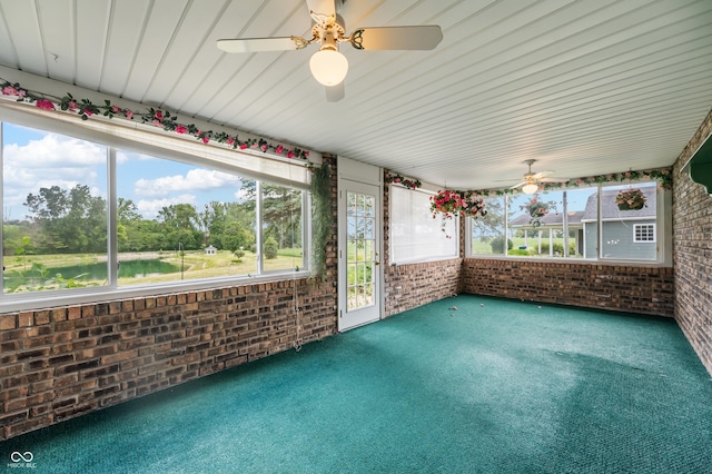 unfurnished sunroom with ceiling fan and a water view