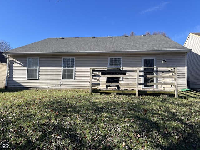 back of property with a wooden deck and a yard