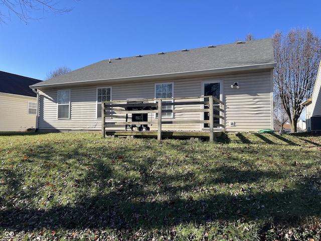 rear view of house with a wooden deck and a lawn