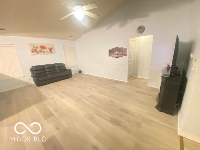 living room featuring ceiling fan, high vaulted ceiling, and light hardwood / wood-style floors