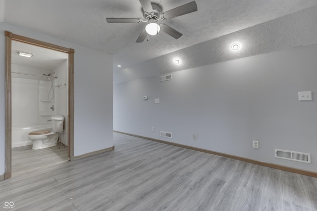 unfurnished room with lofted ceiling, ceiling fan, a textured ceiling, and light wood-type flooring