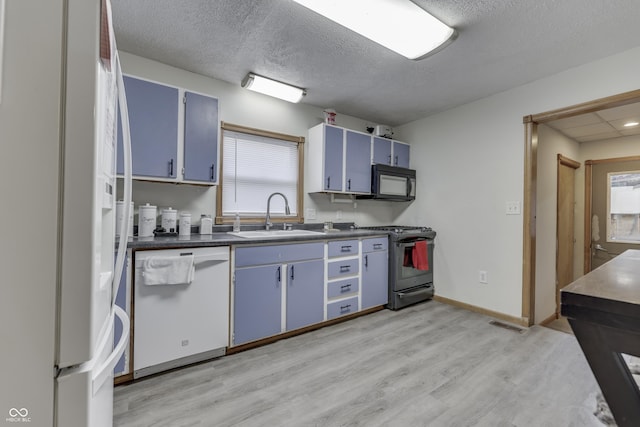 kitchen featuring white appliances, blue cabinets, a healthy amount of sunlight, and sink