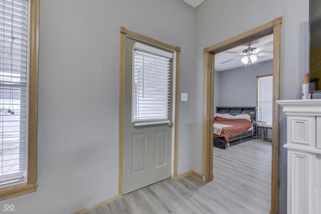 interior space with light wood-type flooring, ceiling fan, and a healthy amount of sunlight