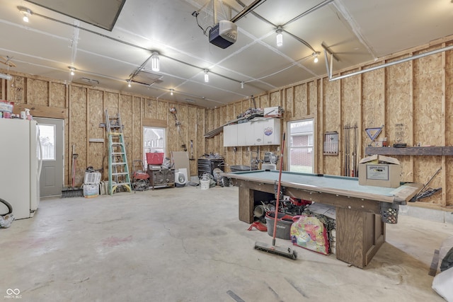 garage with white refrigerator and a garage door opener