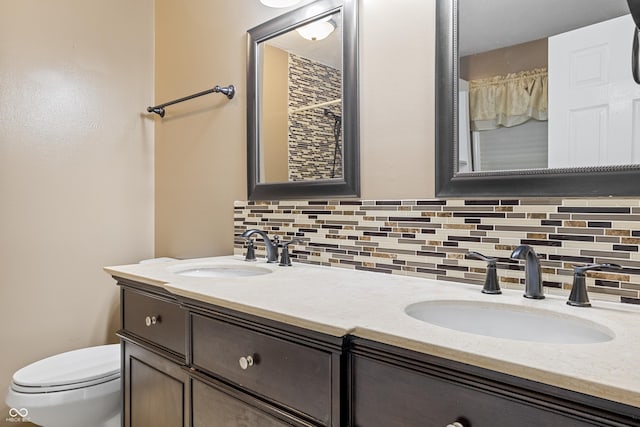 bathroom with decorative backsplash, toilet, and vanity