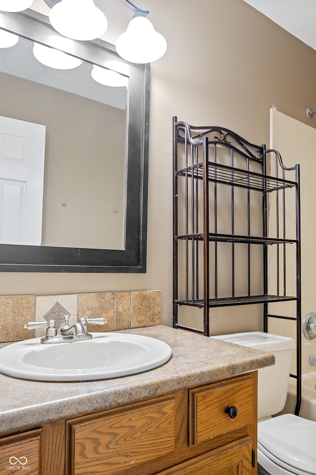 full bathroom featuring shower / tub combination, vanity, tasteful backsplash, and toilet