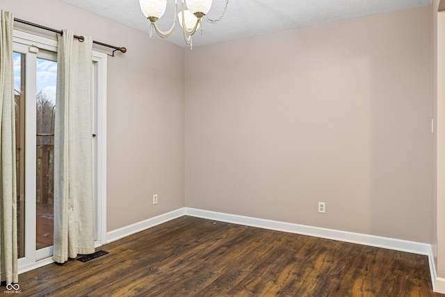 unfurnished room featuring dark hardwood / wood-style floors, a textured ceiling, and an inviting chandelier