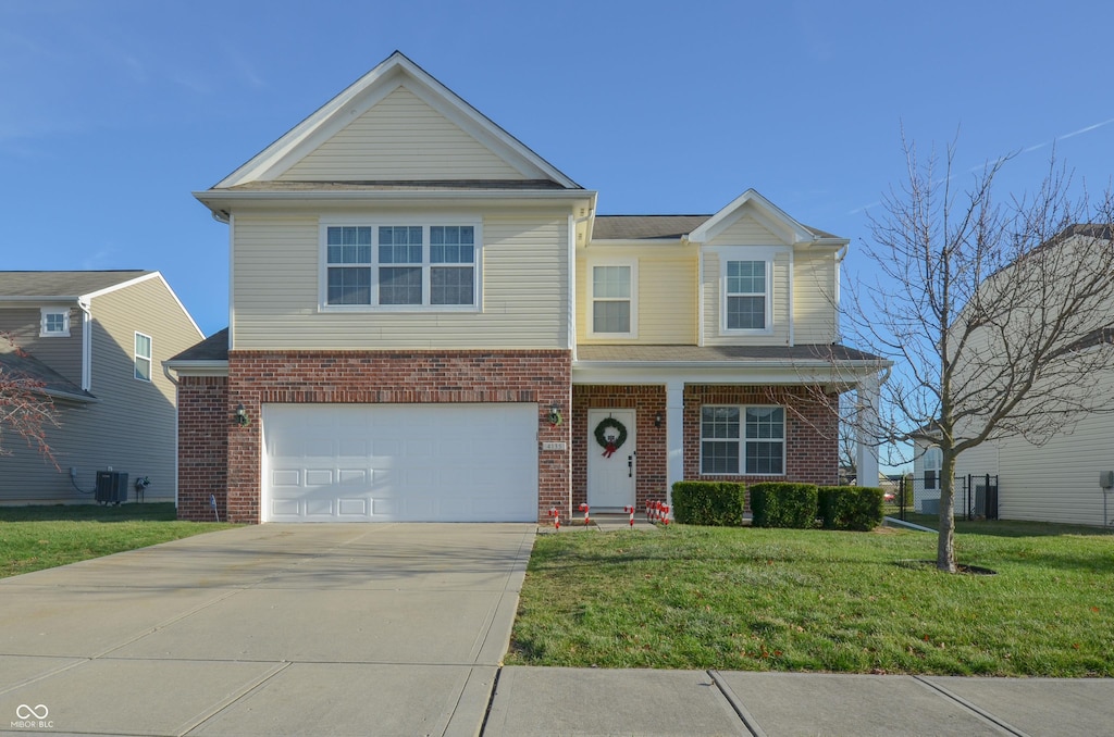 view of front of property featuring a garage, central AC, and a front lawn