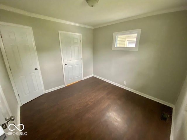 unfurnished bedroom with dark hardwood / wood-style floors and ornamental molding