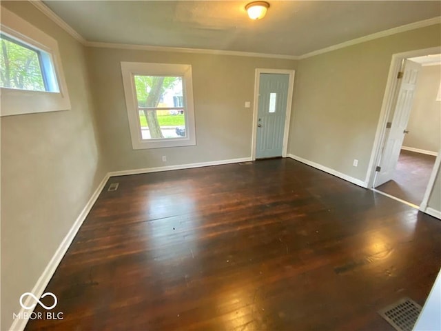 empty room with crown molding and dark hardwood / wood-style floors