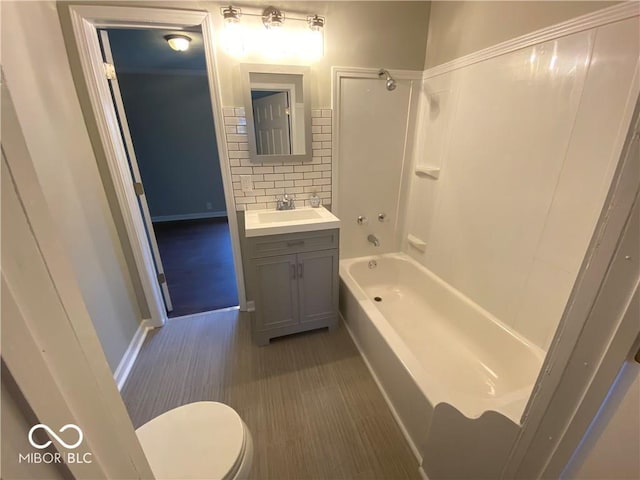 full bathroom with tasteful backsplash, hardwood / wood-style floors,  shower combination, toilet, and vanity