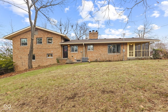 back of property featuring a lawn, a sunroom, and cooling unit