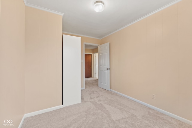 spare room with light carpet and crown molding