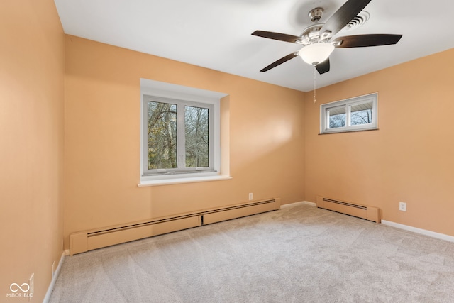 carpeted spare room with ceiling fan and a baseboard heating unit