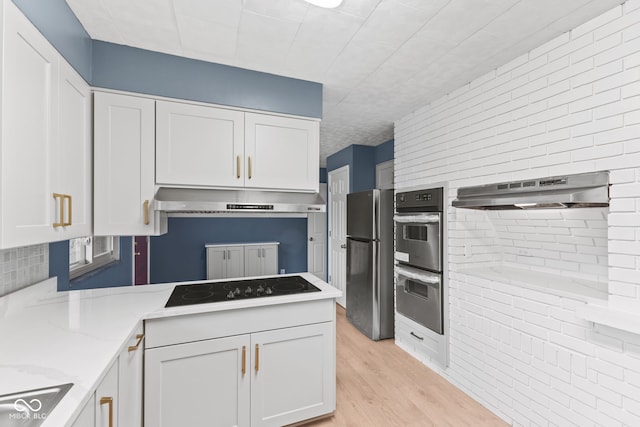 kitchen featuring appliances with stainless steel finishes, white cabinets, light wood-type flooring, and extractor fan